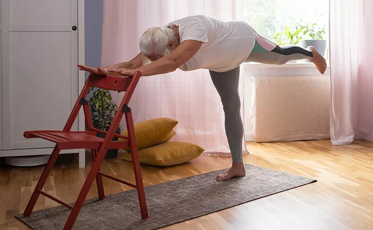 woman using chair for stretching exercise