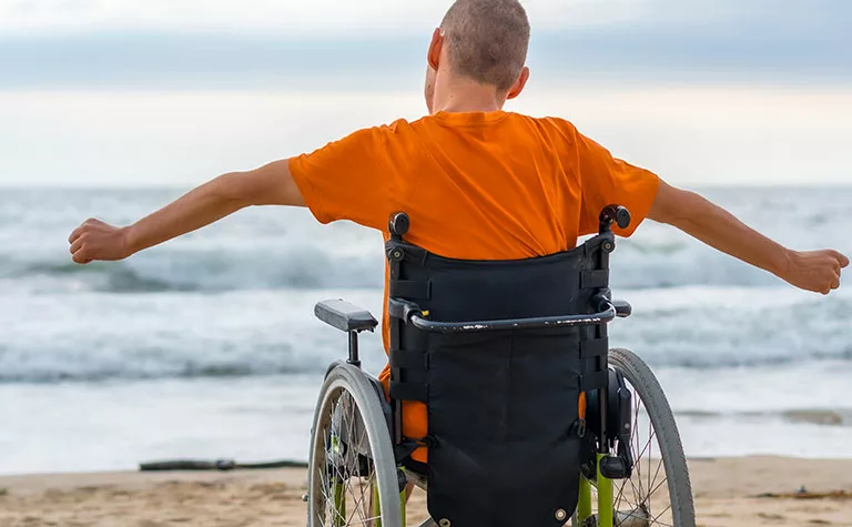 disabled person in wheelchair on the beach